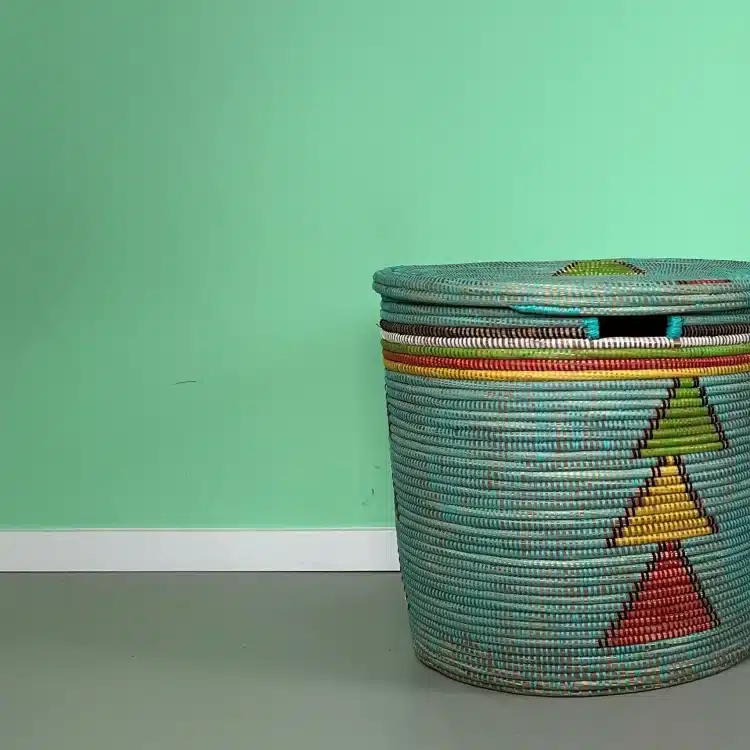 Sfeerfoto van blauwe mand op kinderkamer tegen groene achtergrond