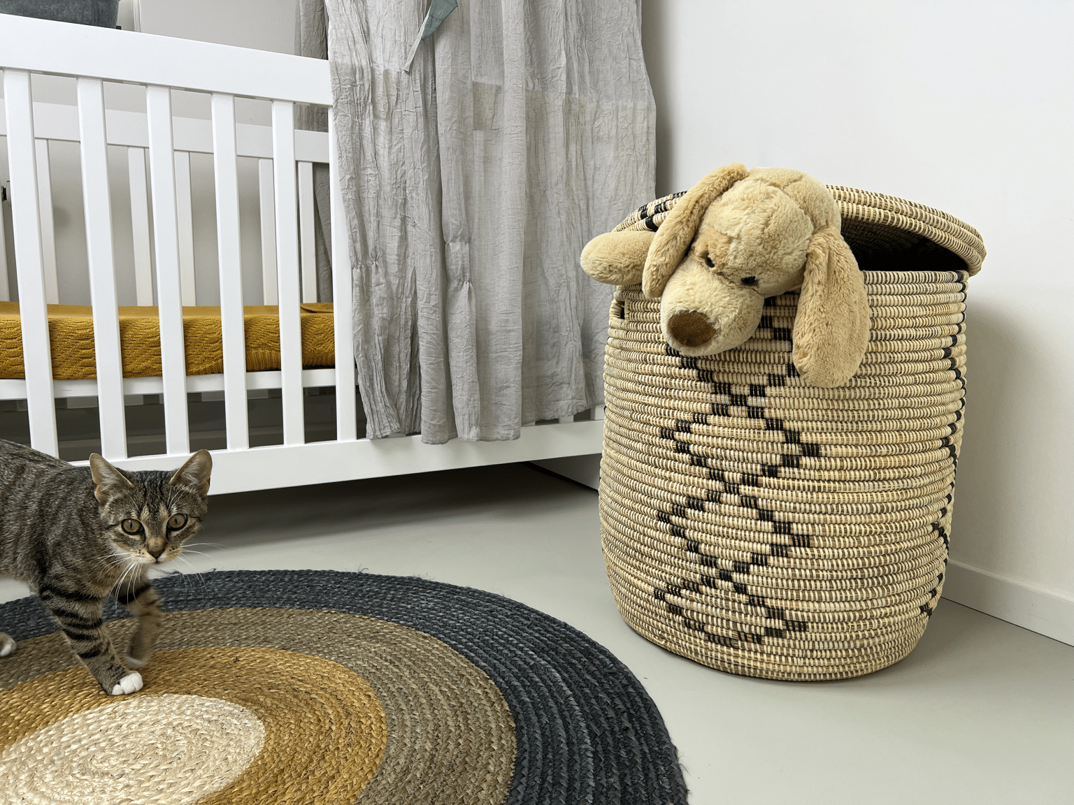 Handgevlochten rieten speelgoedmand met knuffel in een kinderkamer